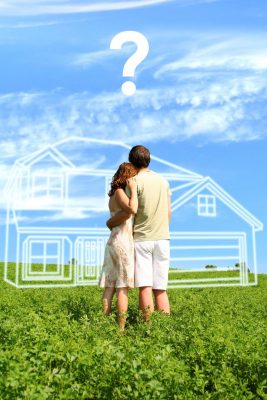 Couple looking at outline of potential home in open land