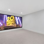 Cinema room in custom home with ceiling to floor, wall to wall screen.