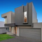 custom new home with modern facade, garage and front grass area